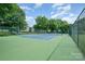 Spacious outdoor tennis court surrounded by lush trees and a fence, perfect for active recreation at 18741 Nautical Dr # 205, Cornelius, NC 28031