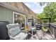 Back deck with comfortable seating, flowers and a grill. Trees and foliage create a natural backdrop at 2004 Marquesas Ave, Tega Cay, SC 29708