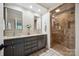Well-lit bathroom with double vanity, tiled floors, and a glass-enclosed shower at 2004 Marquesas Ave, Tega Cay, SC 29708