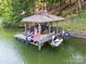 View of the covered boat dock with lounge seating and a boat lift, plus two personal watercrafts at 2004 Marquesas Ave, Tega Cay, SC 29708