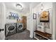 Modern laundry room with front loading washer/dryer, folding rack and a bench with hooks at 2004 Marquesas Ave, Tega Cay, SC 29708