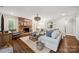 Cozy living room featuring a stone fireplace, hardwood floors, and neutral-toned furniture at 2004 Marquesas Ave, Tega Cay, SC 29708