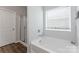 Bright bathroom with a soaking tub, separate shower, and a large window for natural light and ventilation at 204 Fesperman Cir, Troutman, NC 28166