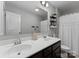Bathroom featuring double sink vanity, toilet, mirror, and decorative shelving, all designed with neutral tones and modern fixtures at 204 Fesperman Cir, Troutman, NC 28166