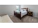 Cozy bedroom with a wooden bed frame, soft carpet, and bright window, creating a relaxing and inviting atmosphere at 204 Fesperman Cir, Troutman, NC 28166
