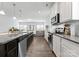 Well-lit kitchen showcasing an island, stainless steel appliances, granite countertops, and wood floors at 204 Fesperman Cir, Troutman, NC 28166