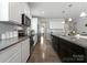 Bright kitchen featuring white cabinets, stainless steel appliances, granite countertops, and wood floors at 204 Fesperman Cir, Troutman, NC 28166