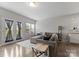 Bright living room with a comfortable gray sofa, hardwood floors, and natural light through sheer-covered French doors at 204 Fesperman Cir, Troutman, NC 28166