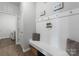 Mudroom featuring built-in bench seating, hooks, decorative accents, and access to the laundry room at 204 Fesperman Cir, Troutman, NC 28166