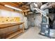 Unfinished basement area with visible pipes, a furnace, a water heater, and a workbench at 207 Welcombe St, Mooresville, NC 28115
