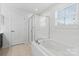Bright bathroom features a bathtub, a glass-enclosed shower, and large window at 207 Welcombe St, Mooresville, NC 28115