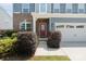 Inviting front entrance with a red door, brick accents, and lush landscaping around the walkway at 207 Welcombe St, Mooresville, NC 28115