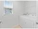 Practical laundry area includes a washing machine, dryer, and window at 207 Welcombe St, Mooresville, NC 28115