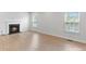 Spacious living room with a cozy fireplace, hardwood floors, and large windows offering plenty of light at 207 Welcombe St, Mooresville, NC 28115
