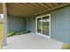 The covered patio features a sliding glass door and landscaping to enjoy the backyard at 207 Welcombe St, Mooresville, NC 28115