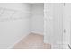 Bright walk-in closet with carpet flooring and white shelving at 207 Welcombe St, Mooresville, NC 28115