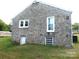 Stone house with a basement door and a glimpse of the spacious yard at 209 14Th Se Ave, Hickory, NC 28602