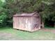 An outdoor storage shed with a wood facade, surrounded by grass and mature trees at 209 14Th Se Ave, Hickory, NC 28602