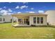 A covered outdoor patio with a well-maintained lawn under a bright, partly cloudy sky at 21214 W Tern Ct, Fort Mill, SC 29707