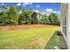 Large grassy backyard with trees and retaining wall at 21214 W Tern Ct, Fort Mill, SC 29707