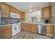 Well-lit kitchen featuring stainless steel appliances, wood cabinets, and decorative backsplash at 21214 W Tern Ct, Fort Mill, SC 29707