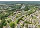 Stunning aerial view of a community with a picturesque lake, pool, clubhouse, and tree-lined streets at 23117 Whimbrel Cir, Fort Mill, SC 29707