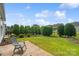 Picturesque backyard featuring a manicured lawn, trimmed hedges, and a stone patio, ideal for outdoor living at 23117 Whimbrel Cir, Fort Mill, SC 29707