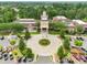 Stunning aerial view of clubhouse, showcasing manicured grounds, clock tower and convenient parking in lush community setting at 23117 Whimbrel Cir, Fort Mill, SC 29707