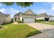 Charming home featuring a well-manicured lawn, neat landscaping, and an attached two-car garage at 23117 Whimbrel Cir, Fort Mill, SC 29707