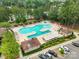 Aerial view of sparkling community pool with lounge chairs, umbrellas and mature trees in a beautiful neighborhood setting at 23117 Whimbrel Cir, Fort Mill, SC 29707
