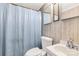 Bathroom featuring neutral wallpaper, a standard white toilet, sink and a shower with a blue curtain at 2742 Flat Creek Rd, Lancaster, SC 29720