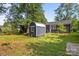 Spacious backyard featuring a storage shed with a metal roof, grassy area, and mature trees at 309 Ackert Ave, Salisbury, NC 28144