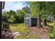 Backyard view featuring a storage shed with a metal roof surrounded by mature trees and green grass at 309 Ackert Ave, Salisbury, NC 28144