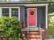 Close-up of a vibrant red front door with wreath, set against gray siding and brick steps at 309 Ackert Ave, Salisbury, NC 28144