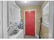 Laundry room featuring a stacked washer and dryer unit and a bright red door at 309 Ackert Ave, Salisbury, NC 28144