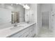 Modern bathroom with double sinks, sleek white cabinetry, and a glass-enclosed shower, exuding contemporary style at 3124 Beacon Heights Rd, Indian Land, SC 29707