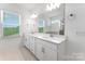 Elegant bathroom with double vanity sinks, white cabinets, and a large mirror, providing a spa-like experience at 3124 Beacon Heights Rd, Indian Land, SC 29707