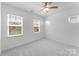 Well-lit bedroom featuring plush carpet flooring, large windows and a ceiling fan at 3124 Beacon Heights Rd, Indian Land, SC 29707