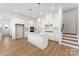 Spacious kitchen with a central island, white cabinets, and stainless steel appliances, complemented by hardwood floors at 3124 Beacon Heights Rd, Indian Land, SC 29707