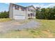 Two-story home with vinyl siding, brown shutters, attached garage, and a large gravel parking area at 3401 Shillinglaw Rd, Sharon, SC 29742