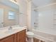 Bathroom featuring a tub and shower combo, wood cabinets and bright lighting at 463 Delta Dr, Fort Mill, SC 29715