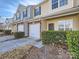 View of townhouses each featuring a one car garage, brick, and beautiful front landscaping at 463 Delta Dr, Fort Mill, SC 29715
