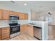 Modern kitchen with stainless steel appliances, natural wood cabinets, and a view of dining room at 463 Delta Dr, Fort Mill, SC 29715