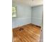 This bedroom features light blue paneled walls, hardwood floors, and a bright window, creating a cozy atmosphere at 490 S Moose Rd, Mount Pleasant, NC 28124