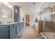 Bathroom featuring a double sink vanity, soaking tub, glass enclosed shower, and tile flooring at 516 Fair Oaks Dr, Fort Mill, SC 29708