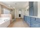 Bathroom featuring a double sink vanity, soaking tub, glass enclosed shower, and tile flooring at 516 Fair Oaks Dr, Fort Mill, SC 29708