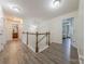 Upstairs hallway with wooden floors, chandelier, and doorway to a bedroom suite at 516 Fair Oaks Dr, Fort Mill, SC 29708