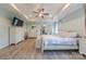 Spacious main bedroom with tray ceiling, ensuite exercise area, light walls, and wood-look flooring at 516 Fair Oaks Dr, Fort Mill, SC 29708