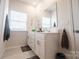 Bright bathroom with white cabinets, modern fixtures, and a decorative mirror at 5440 Kinsbridge Dr, Charlotte, NC 28227