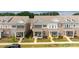 Attractive townhomes featuring manicured lawns, colorful flowers, and inviting covered front porches at 5440 Kinsbridge Dr, Charlotte, NC 28227
